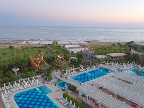 Un resort con varias piscinas, una noria y una zona de playa.