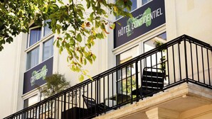 A hotel with balconies, a coffee shop sign, and a sign for 'Hôtel Confidentiel'. - Markus (Angers)