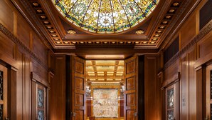 A grand hallway with ornate wooden doors, a stained glass ceiling, and a large mural on the back wall. - Park Hyatt Vienna (Vienna)