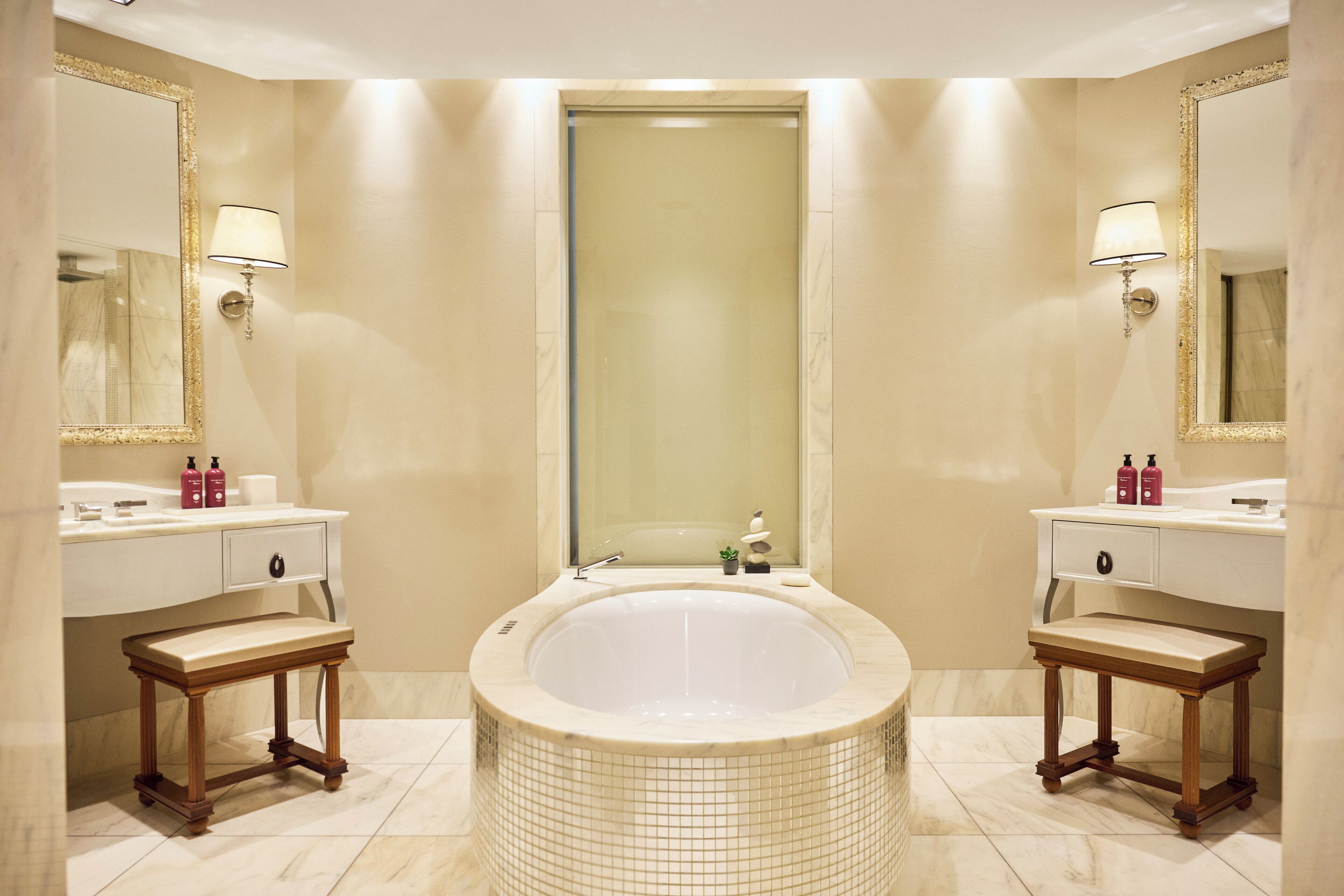 Ein Badezimmer mit einer großen Badewanne, zwei Waschbecken und einem Spiegel.