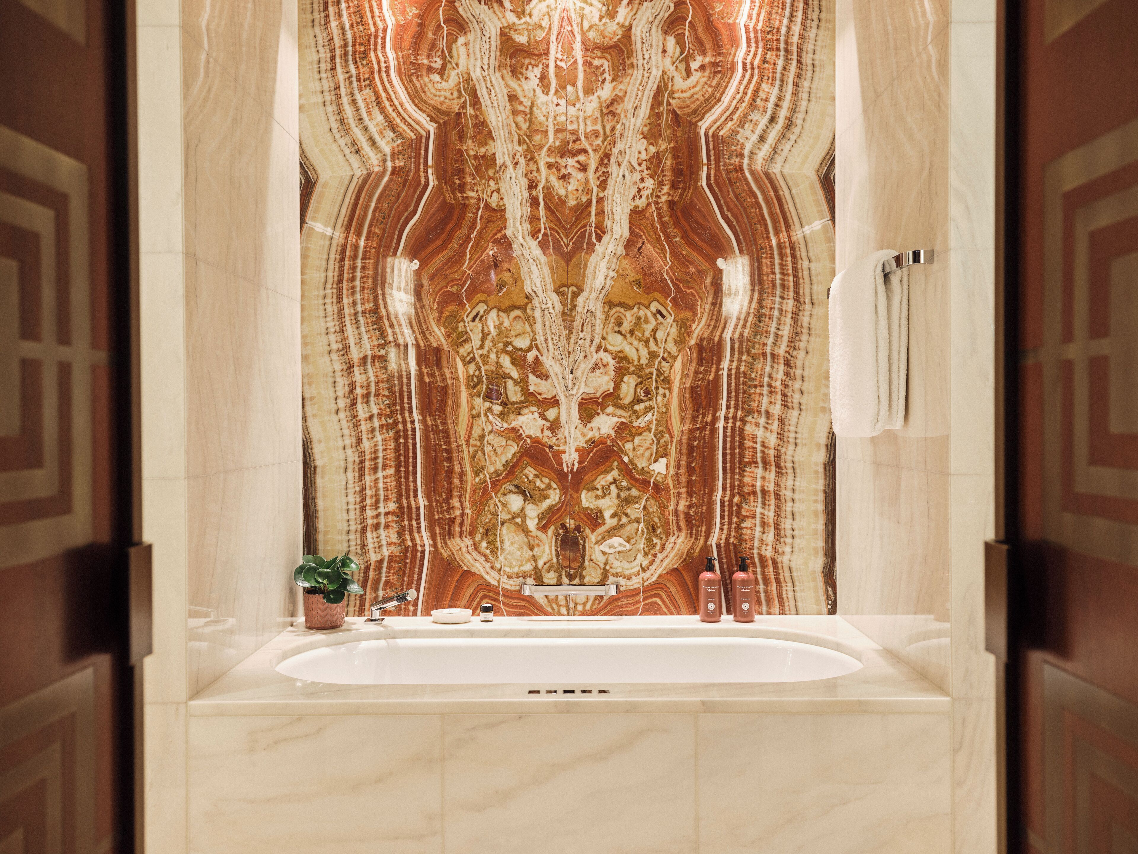 A bathroom with a marble vanity, a sink, and a mirror.