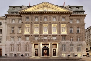 Um grande e histórico edifício com entrada imponente, colunas e uma placa com a inscrição "Park Hyatt Vienna".