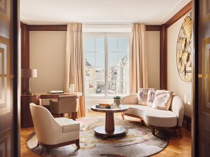 A spacious living room with a large window, a round coffee table, and a sofa.