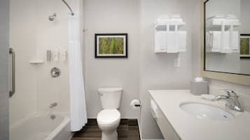 A modern bathroom with a bathtub, toilet, and sink.