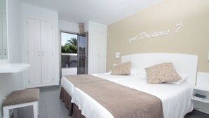 A bedroom with a bed, a nightstand, a chair, and a wardrobe. - Apartments Turbo Club (San Bartolomé de Tirajana)