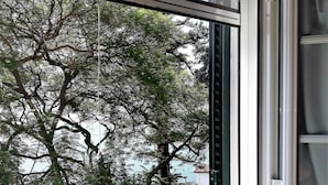 Ein Fenster mit Blick auf Bäume und ein Gebäude.
