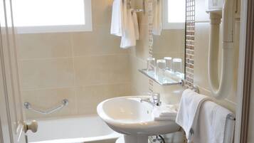 Une salle de bain avec une baignoire, un lavabo et un porte-serviettes.