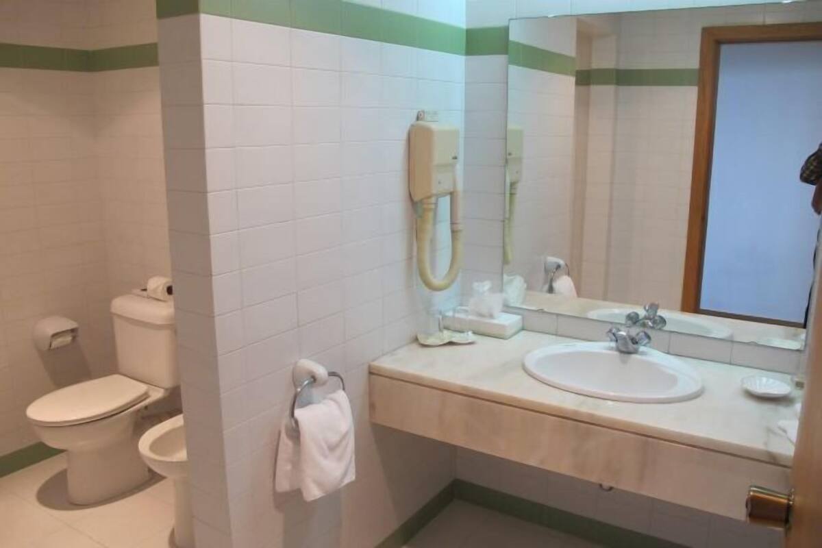 Bany amb vàter, bidet, rentamig i mirall.
