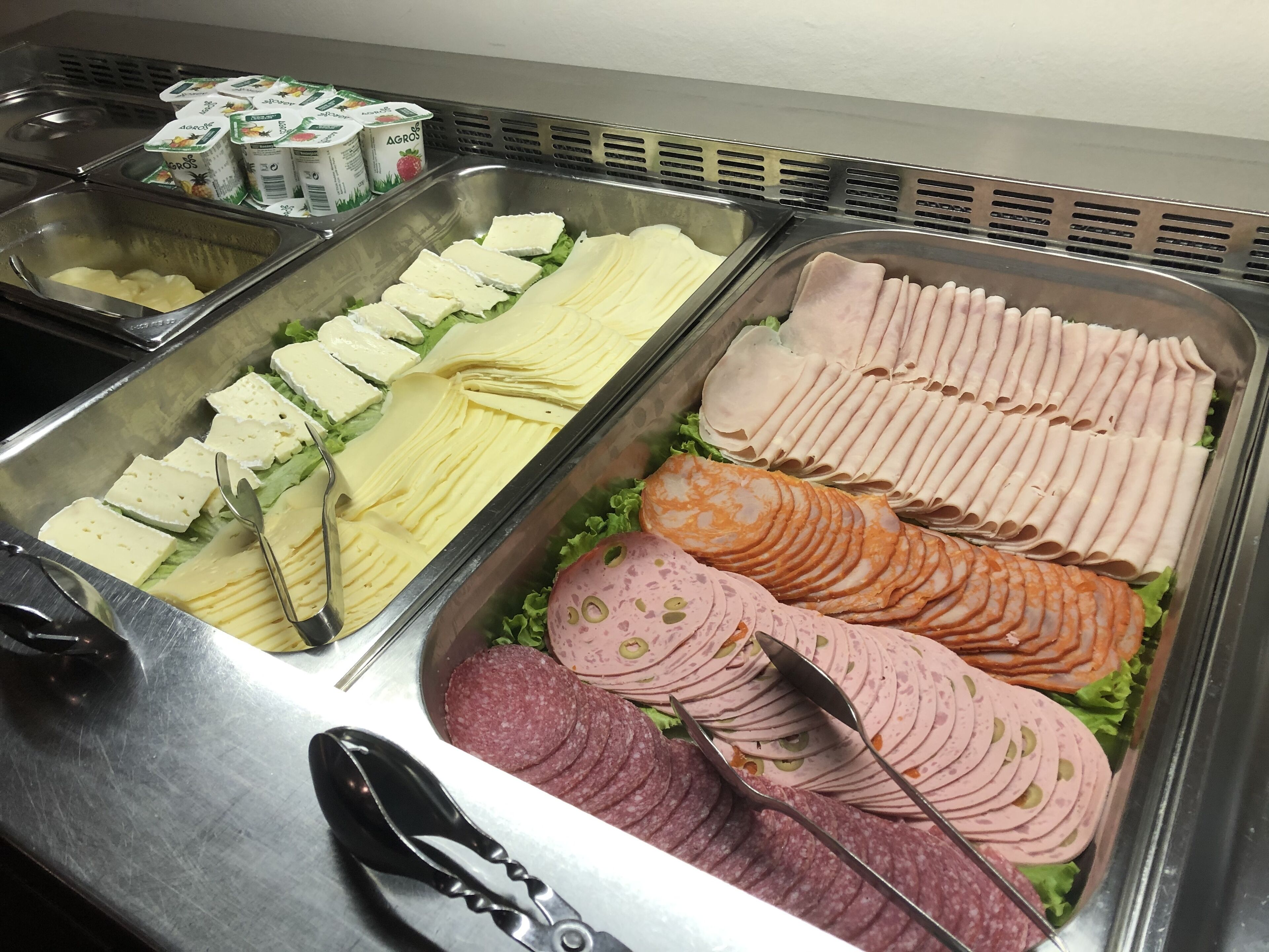 Ein reichhaltiges Buffet mit verschiedenen Speisen, darunter Käse, Schinken und Aufschnitt.