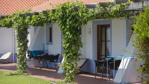A building with a covered outdoor seating area, a door, and a window. - Casa Vicentina (Aljezur)
