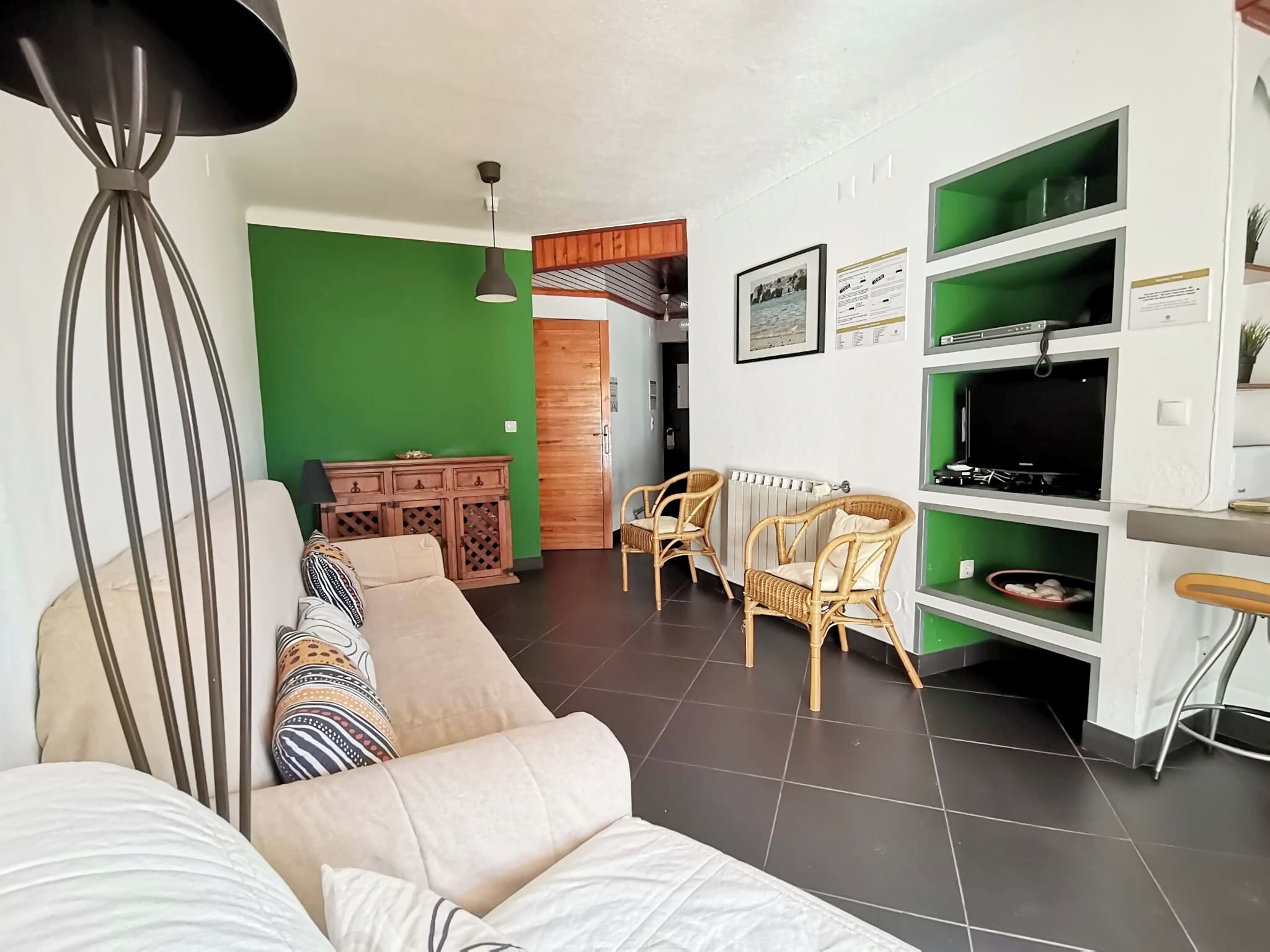 A living room with a sofa, chairs, a dining table, and a TV.