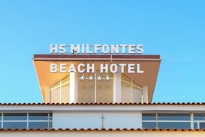 Das Äußere des HS Milfontes Beach Hotels bei blauem Himmel.