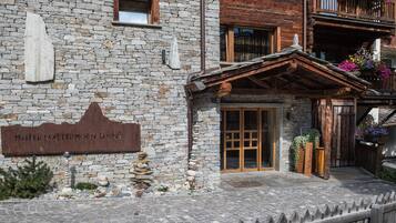 Un edificio de piedra con un balcón de madera y un letrero que dice "Hotel Matterhorn Lodge".