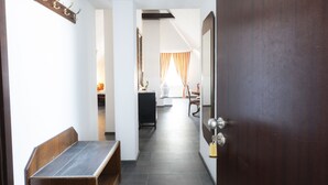 A hallway with a bench, a coat rack, and a door with a lock. - Hotel Astoria am Urachplatz (Stuttgart)