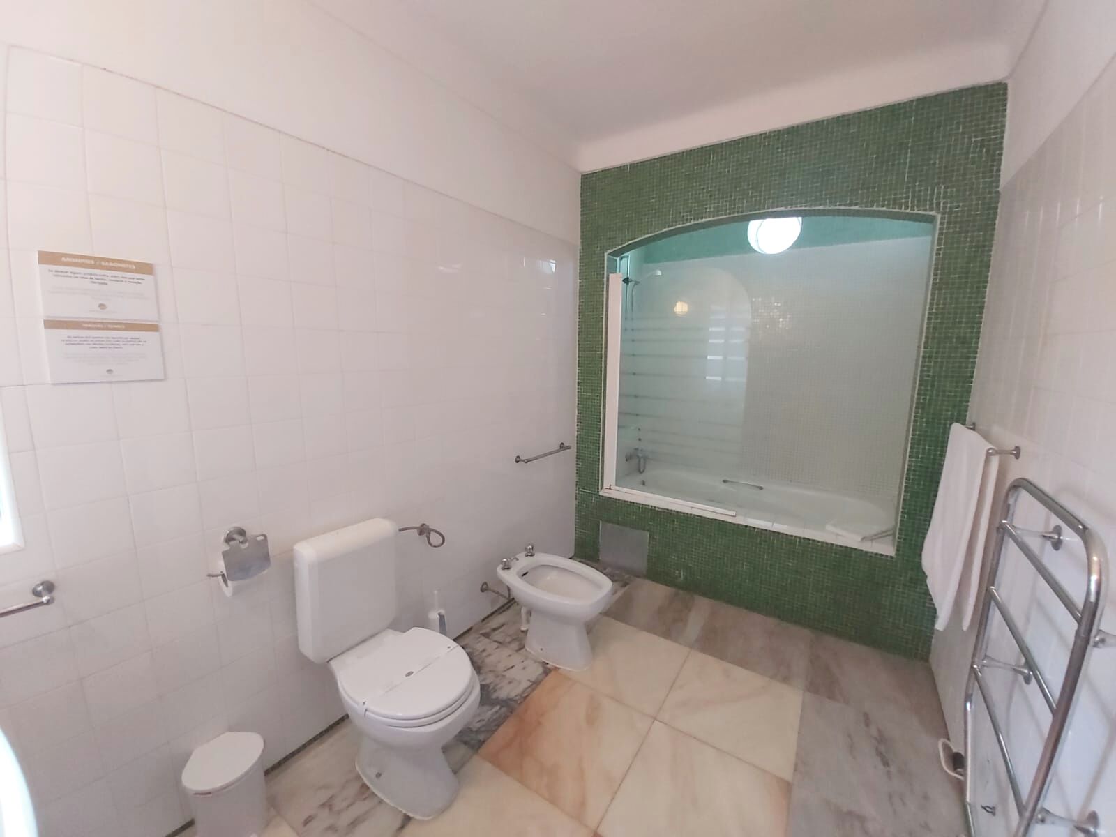 A bathroom with a toilet, bidet, and a glass-enclosed shower area.