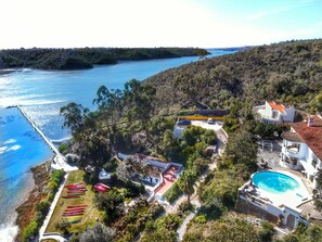Una propiedad costera con piscina, muelle y zona de almacenamiento para embarcaciones.