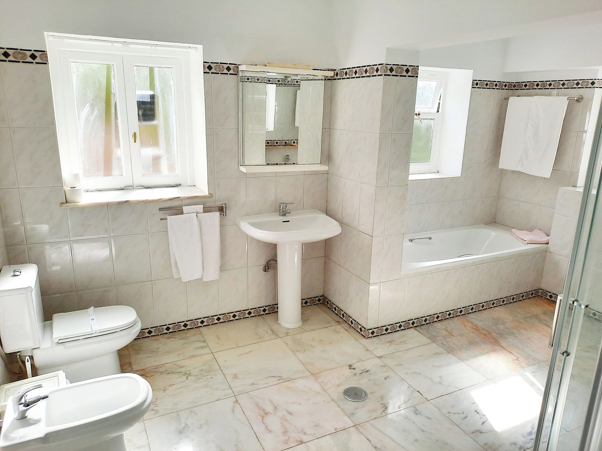 Een badkamer met toilet, wastafel en bad.
