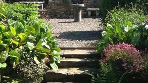 A stone staircase leading to a stone wall with a circular window. - Plumpton Court (York)