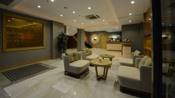 A modern lobby with seating areas, a reception desk, and a large window. - Olimpiyat (Istanbul)