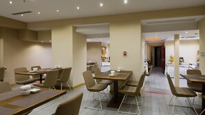 A modern dining area with multiple tables and chairs, a neutral color scheme, and a clean, organized layout. - Olimpiyat (Istanbul)