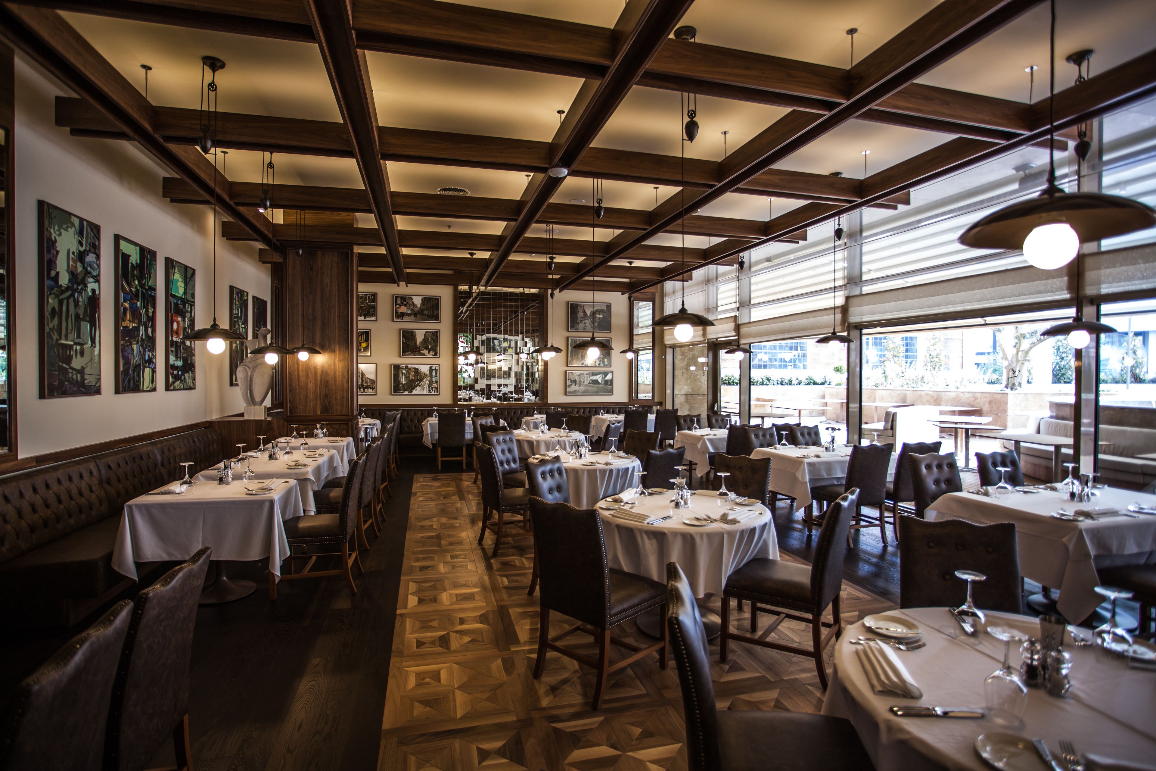 Un restaurante con varias mesas, sillas y un suelo estampado.