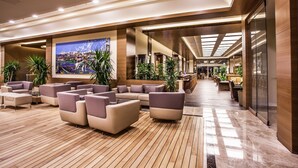 A spacious lobby with modern furniture, a large cityscape painting, and a well-lit ceiling. - Gorrion Hotel Istanbul (Istanbul)