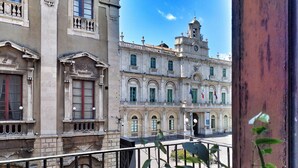 Un edificio histórico con arquitectura clásica, que presenta varios balcones y una torre del reloj.