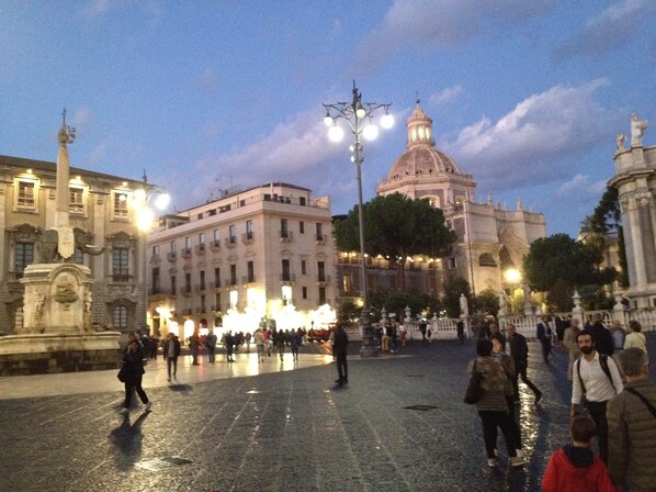 A public square with historic buildings, a prominent dome, and a statue. - Ostello Degli Elefanti (Catania)