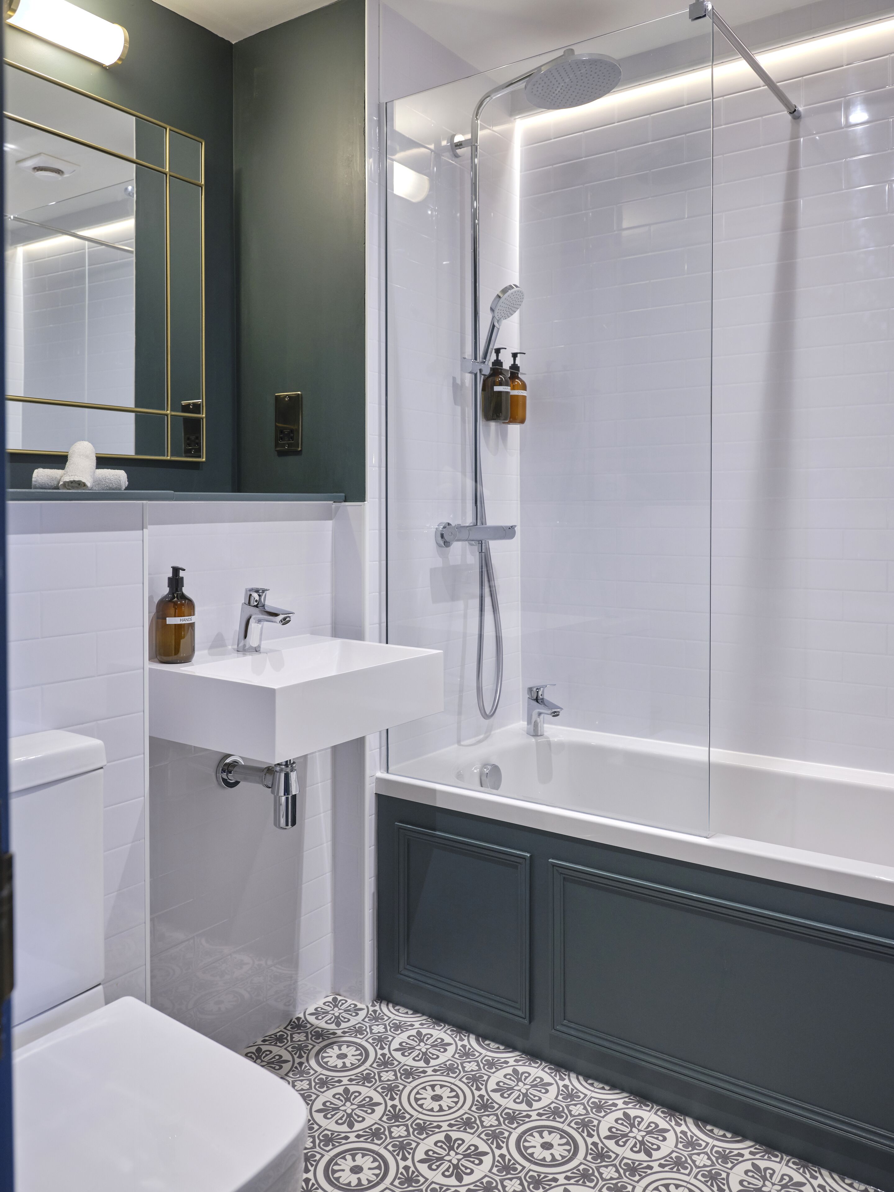 A modern bathroom with a shower, sink, and toilet.