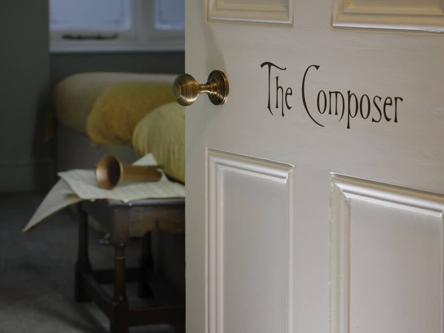 A door labeled "The Composer" with a brass doorknob.