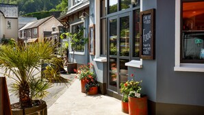 Un bâtiment doté de grandes fenêtres et d’une enseigne indiquant : « Large choix de plats chauds et froids ».