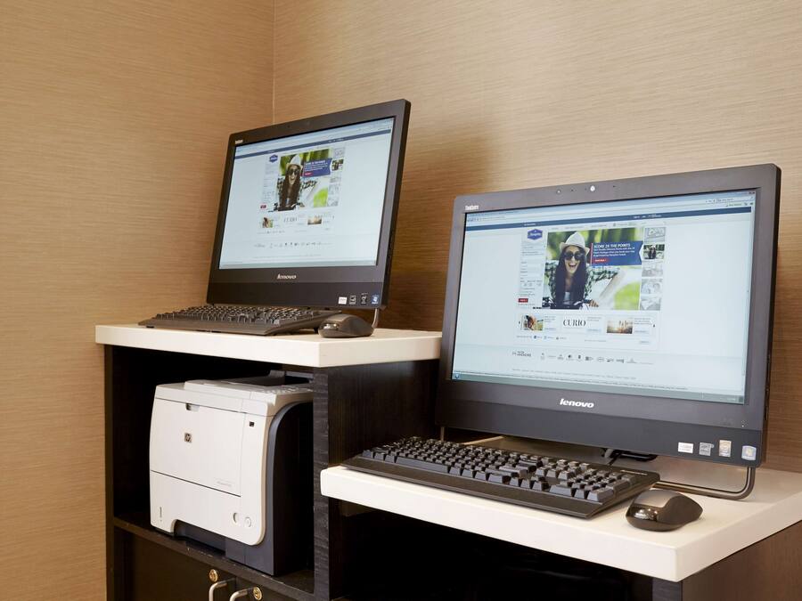 Dos computadoras de escritorio sobre un escritorio con una impresora y un teclado.