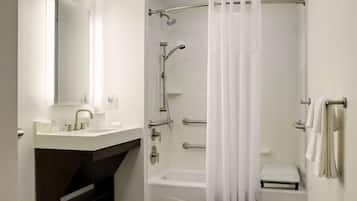 A modern bathroom with a white sink, a bathtub, and a shower with a curtain.