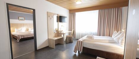 Una habitación de hotel moderna con techo de madera, una cama grande, un escritorio y un espejo.