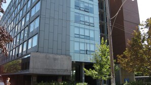 Ein modernes Gebäude mit Glasfassade und Betonsockel.