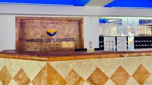 Un comptoir d’accueil avec un logo, un panneau en bois et un présentoir avec des panneaux d’information.