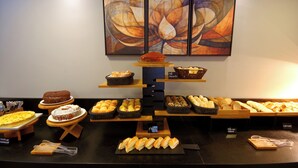 A bakery display with various pastries and breads. - Fenix Moema (São Paulo)