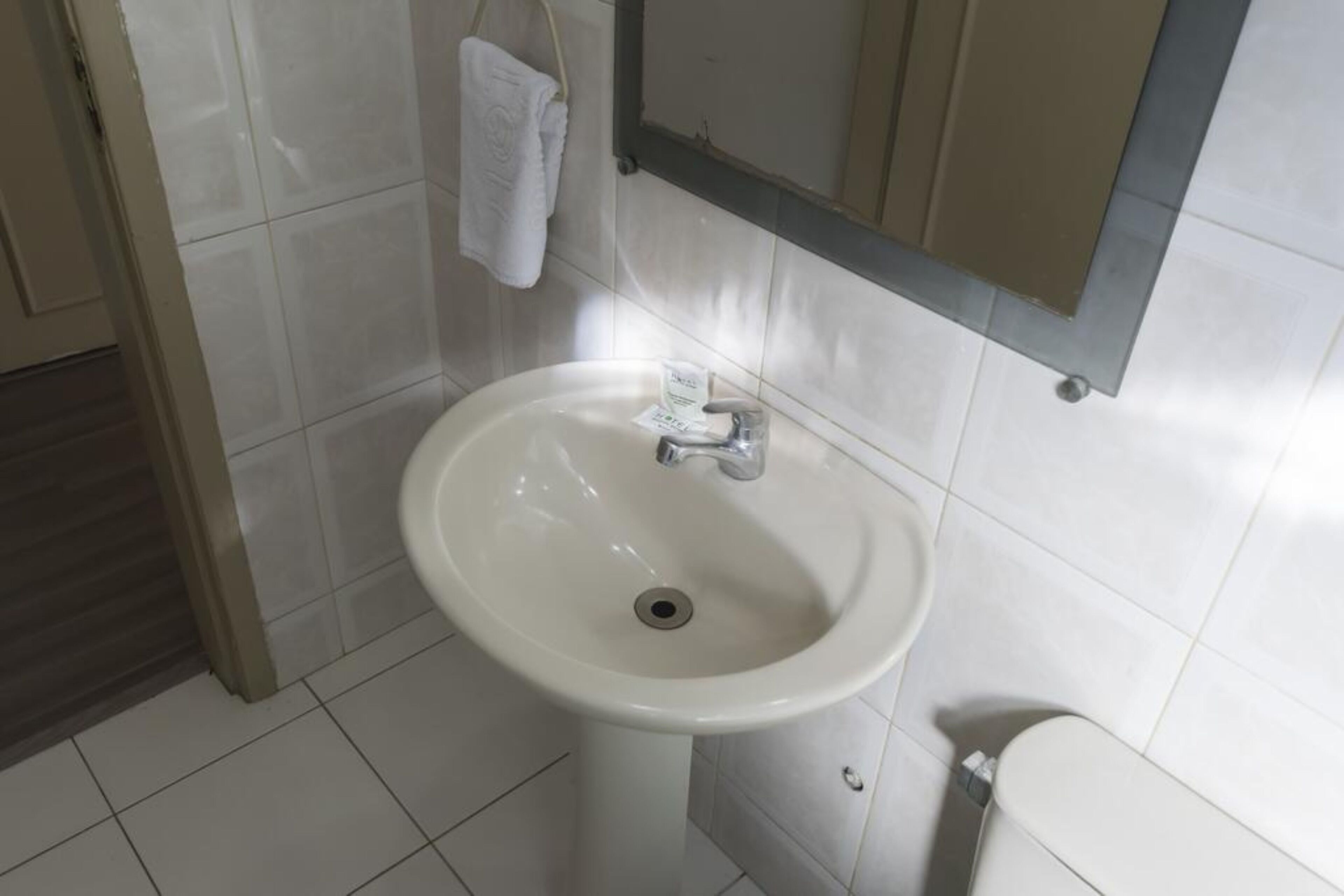 A bathroom with a white sink, a mirror, and a toilet.
