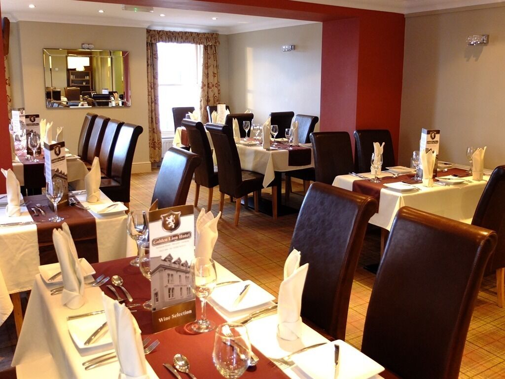 A restaurant with tables set for dining, including wine glasses and cutlery.