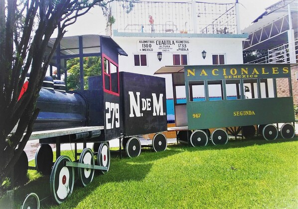 A vintage train with "Nacionales Demexico" and "Segunda" on the side, parked on grass.