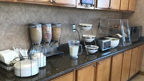 A buffet setup with cereal, yogurt, and a coffee station. - The Soluna Hotel (El Paso)