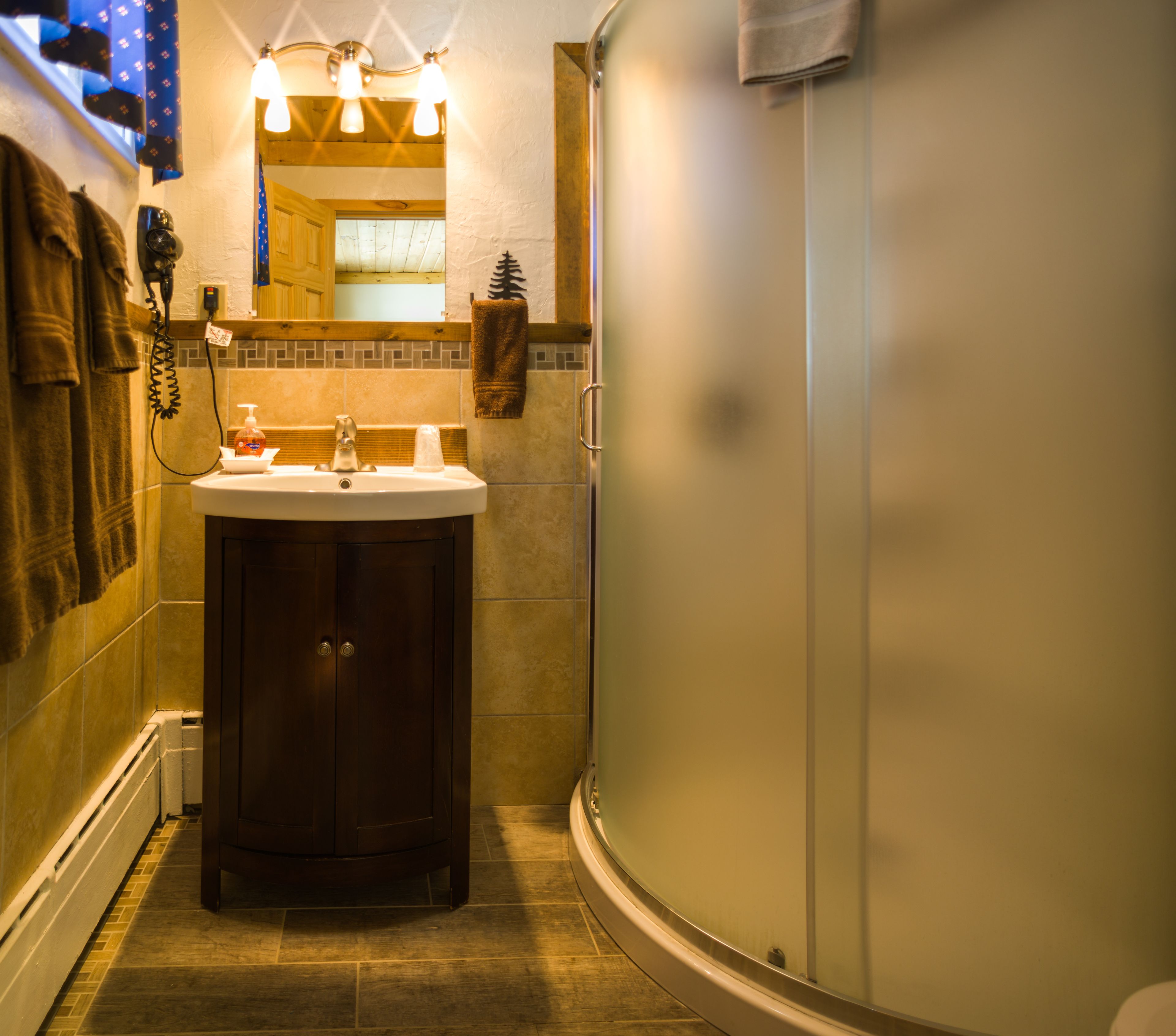 A bathroom with a sink, mirror, towel rack, and shower.