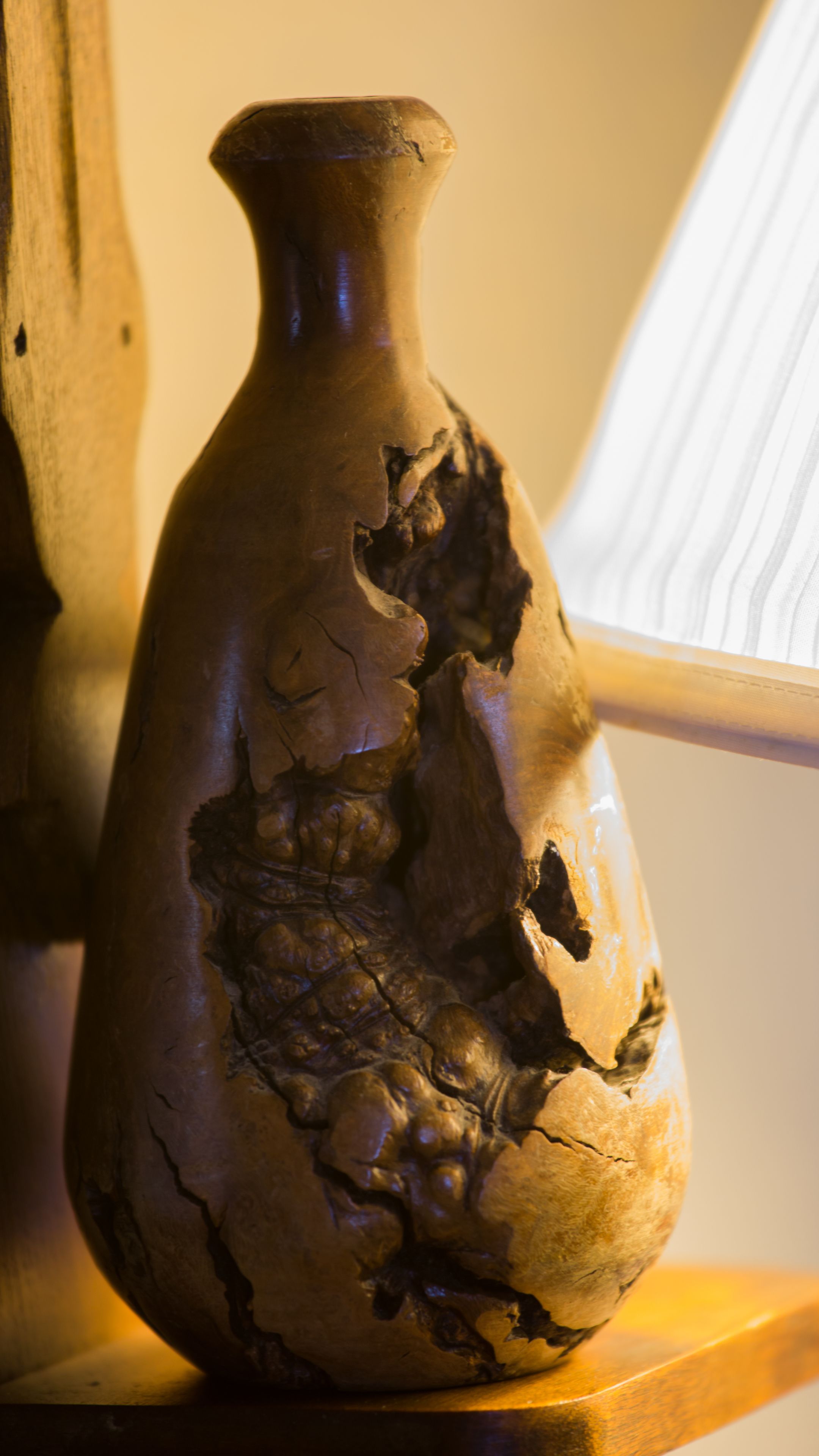 A vase with a textured surface and a crack running down its side.