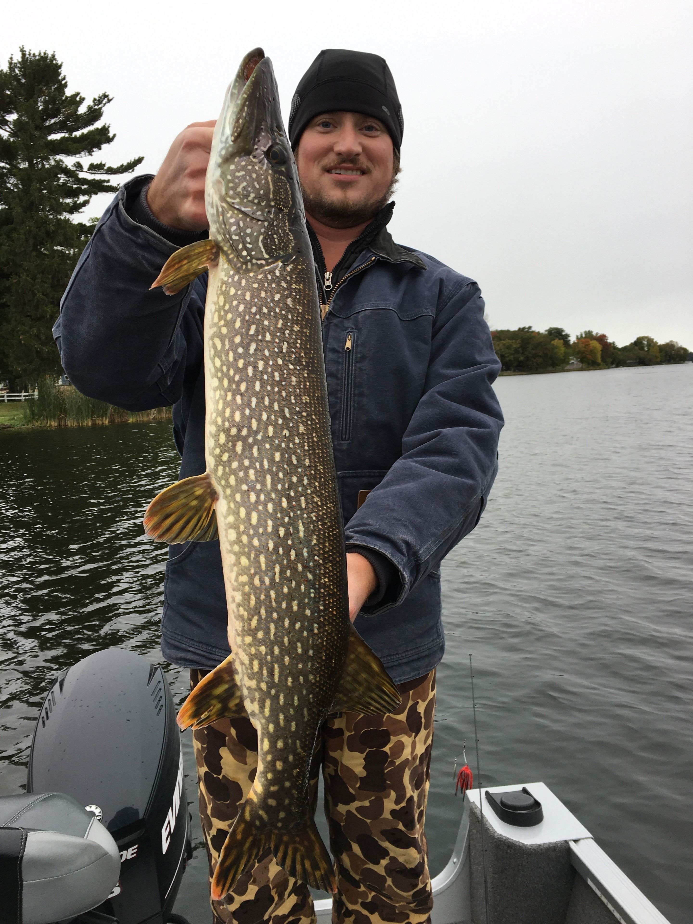 A person holding a large fish on a boat.