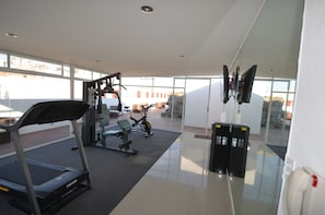 Een moderne sportschool met trainingsapparatuur, grote ramen en een ruimtelijke, schone indeling.