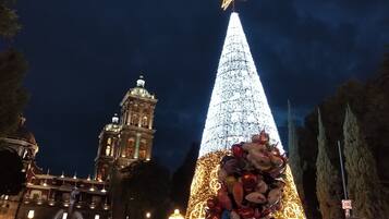 A large, illuminated Christmas tree with a star on top, surrounded by a crowd.