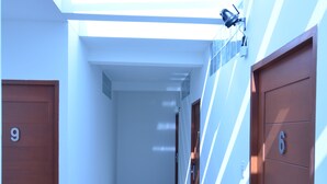 Een gang met deuren met de nummers 9 en 6, die naar kamers leiden.