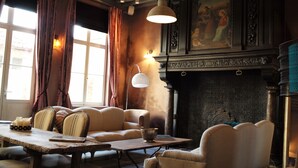 Una habitación acogedora con chimenea, asientos cómodos y una mesa con velas.