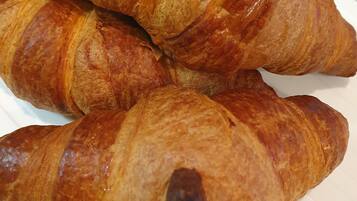 Four croissants on a white plate.