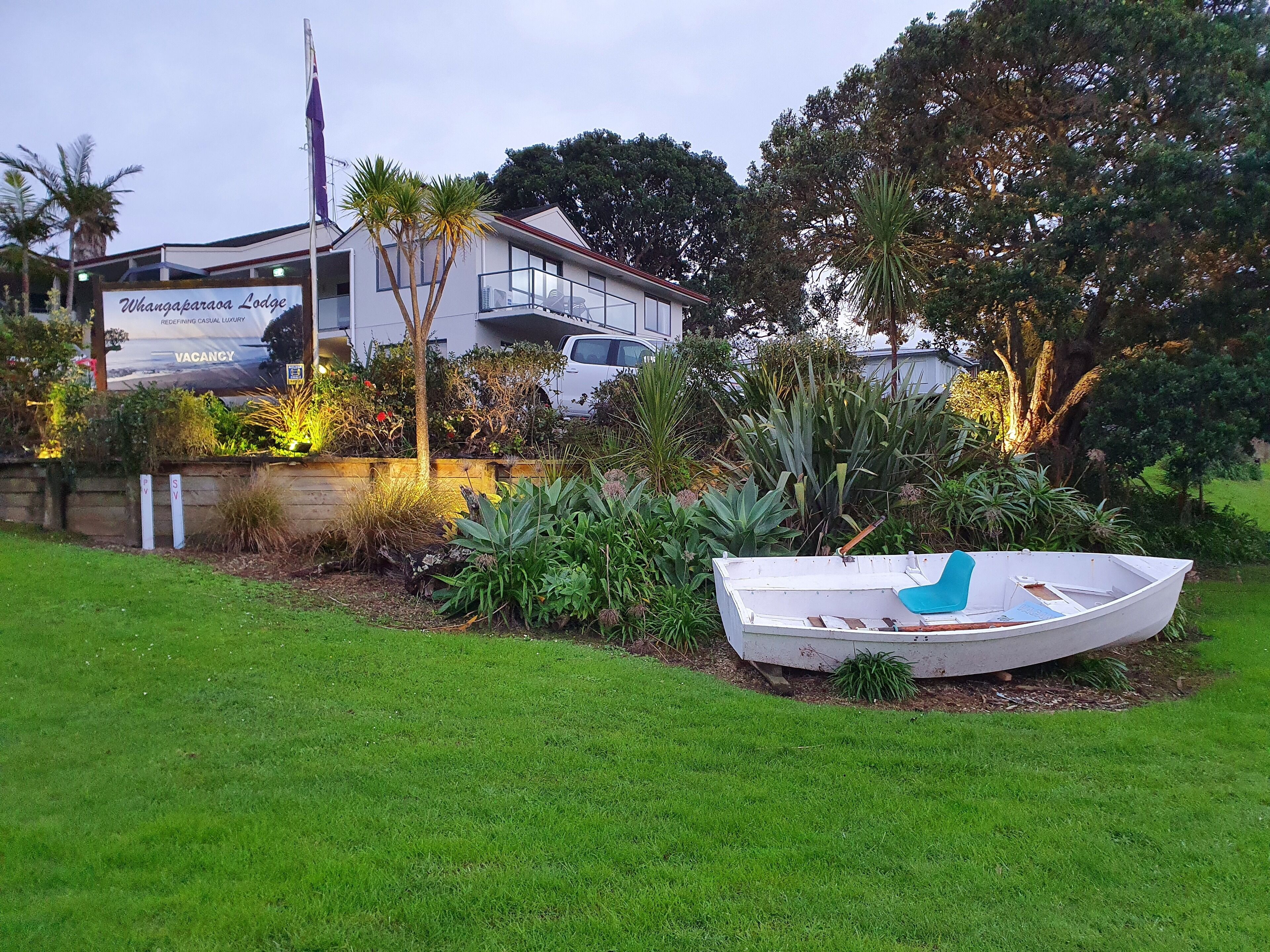A house with a signboard advertising 'Whangaparaoa Lodge' and a vacant status.
